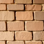 A traditional ceramic brick used for building a sauna, shown in detail with visible texture and earthy tones, arranged in a rustic construction pattern