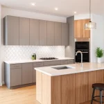 A modern kitchen renovation scene showing a freshly renovated kitchen with sleek cabinetry, a minimalist island, a backsplash with geometric tiles, a stainless steel sink, and a subtle lighting fixture. The space should reflect thoughtful design, with clean lines, natural wood accents, and a touch of greenery. No people or text should be present.