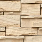 A close-up view of natural stone panels used for cladding a building facade, showcasing the texture, color variations, and subtle shadows that highlight the stone's depth and craftsmanship, with a neutral background that emphasizes the stone's surface details